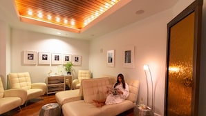 A modern living room with a sofa, armchairs, a wooden ceiling, and framed pictures on the wall. - BC 202A Gulf Front with Daily Beach Chair Set! (Pensacola Beach)