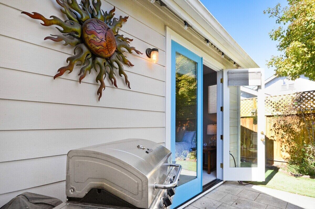 Een huis met een barbecue en een decoratieve zon op de muur.