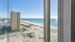 Een hoog hotel met uitzicht op een strand en de oceaan.