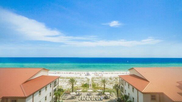 Vista de un resort con playa, cielo despejado y océano.