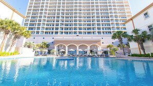 A hotel with a large pool, a multi-story building, and palm trees. - Dly Beach Chairs! -Beach Club 3B Gulf Front @ Pensacola Bch (Pensacola Beach)
