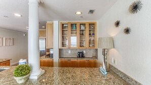 Uma cozinha com bancadas de granito, armários de madeira e adega embutida.