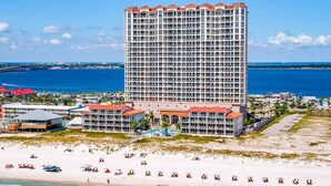 Um hotel alto com várias varandas, localização à beira-mar e vista para o oceano.