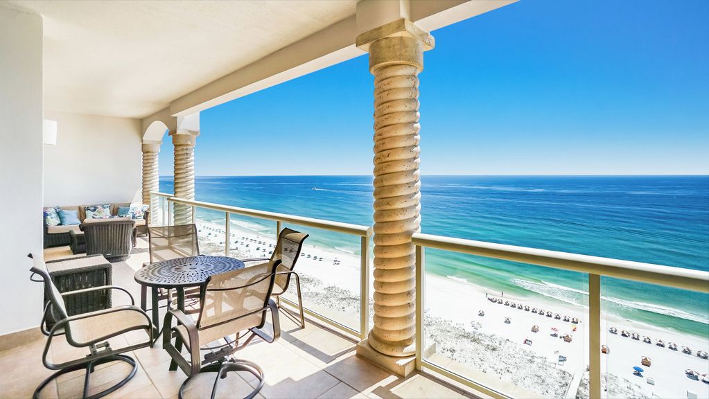 Ein Balkon mit Blick auf den Strand und das Meer.