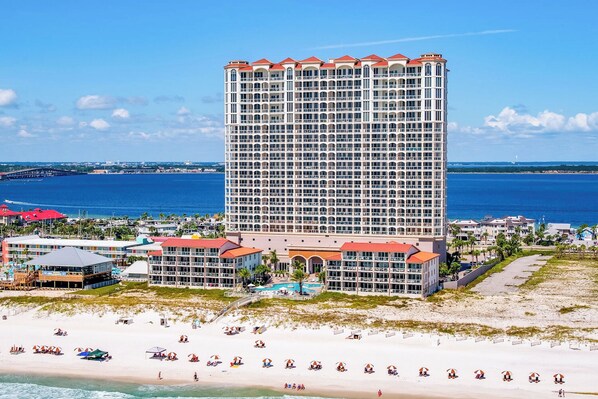 Un hôtel de grande hauteur doté de nombreux balcons, situé en bord de mer et offrant une vue sur l’océan.