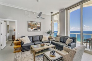 Relax in this spacious living room with a sofa, coffee table, and side table, offering a view of the ocean.