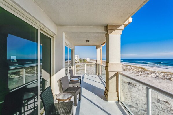 Relax on the balcony with unobstructed views of the beach and ocean.