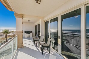 Enjoy the ocean view from this balcony with a seating area and large window.