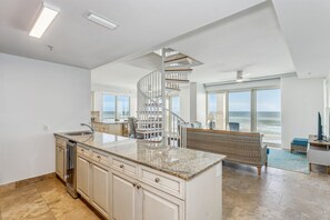 Enjoy ocean views from the spacious living area with a prominent kitchen island and large windows.
