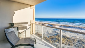 A balcony with a view of the beach and ocean.