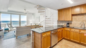A modern kitchen with wooden cabinets, a built-in dishwasher, and a large island.
