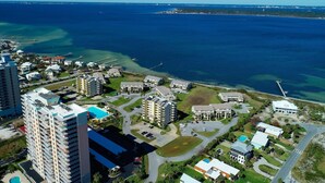 An aerial view of a coastal resort area with multiple buildings, a marina, and clear blue waters. - Beach and Bay Views at Santa Rosa Dunes! (Pensacola Beach)