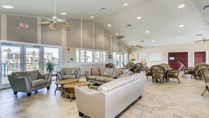A spacious lobby with leather sofas, wicker chairs, and a large white couch. - Beach and Bay Views at Santa Rosa Dunes! (Pensacola Beach)