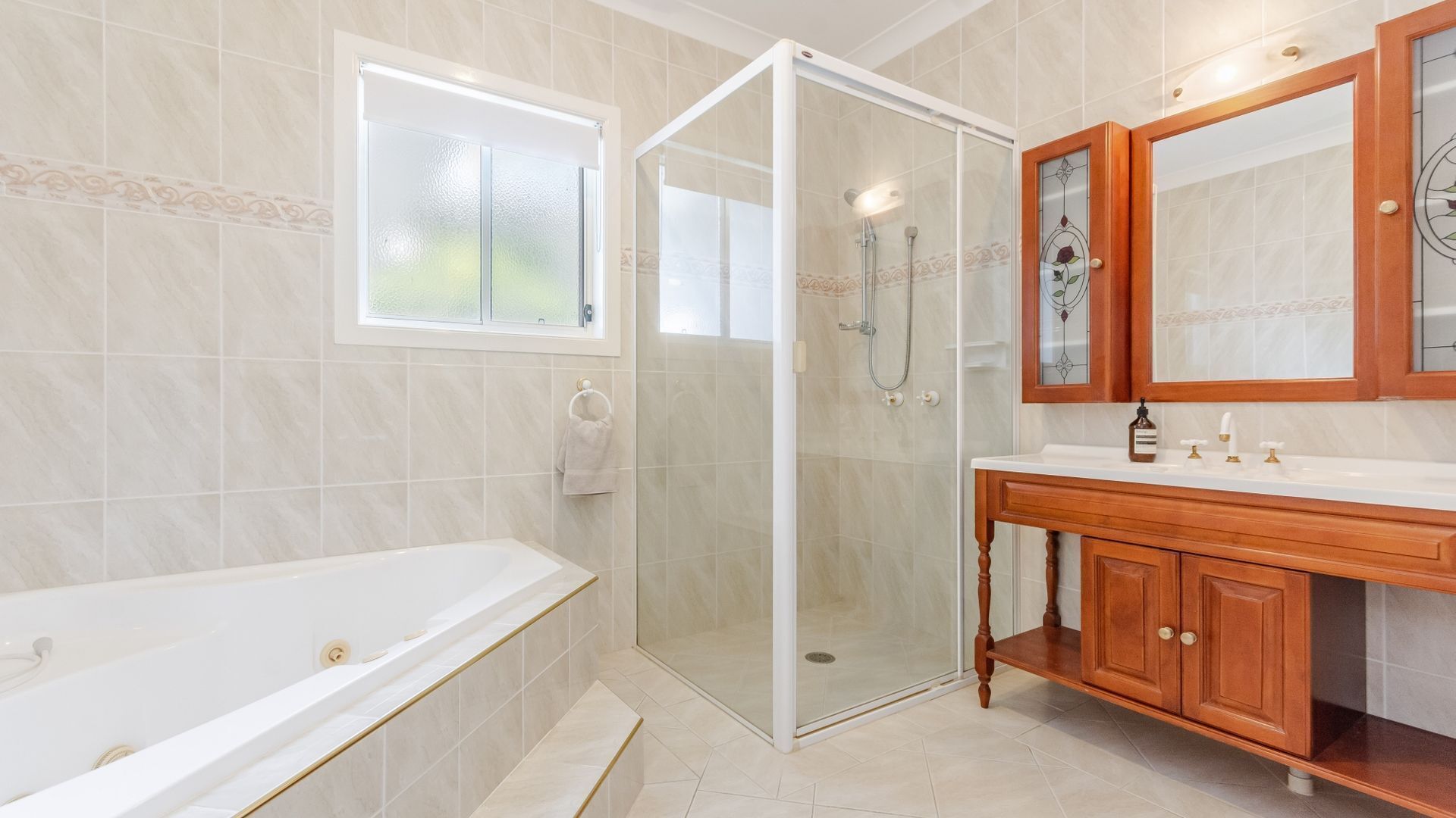 A modern bathroom with a glass-enclosed shower, a freestanding bathtub, and a wooden vanity with a mirror.