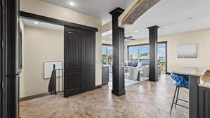 A spacious kitchen with dark cabinetry, a bar area, and a view to the outside. - Roof Top Pool at the High Life - 1 Block from the Beach! (Pensacola Beach)