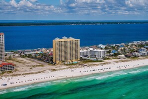 A coastal resort with a beachfront, high-rise hotel, and residential buildings. - Emerald Isle Gulf Front Dreams*Daily Beach Chairs- EI 0102 (Pensacola Beach)