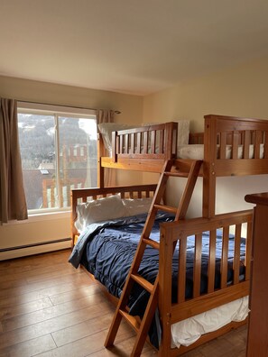 Cozy room with a bunk bed arrangement, featuring a lower and upper bunk with a wooden headboard.
