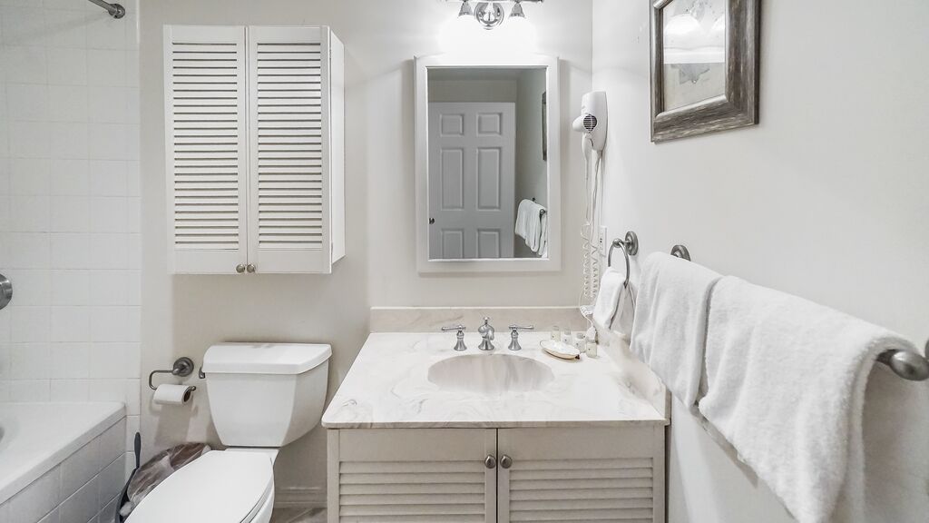 Un baño con inodoro, lavabo y espejo.