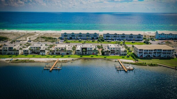 An aerial view of a coastal hotel with multiple buildings, a beach, and a marina. - Bay Front- Water Access- 3B/ Great for Families! (Pensacola Beach)