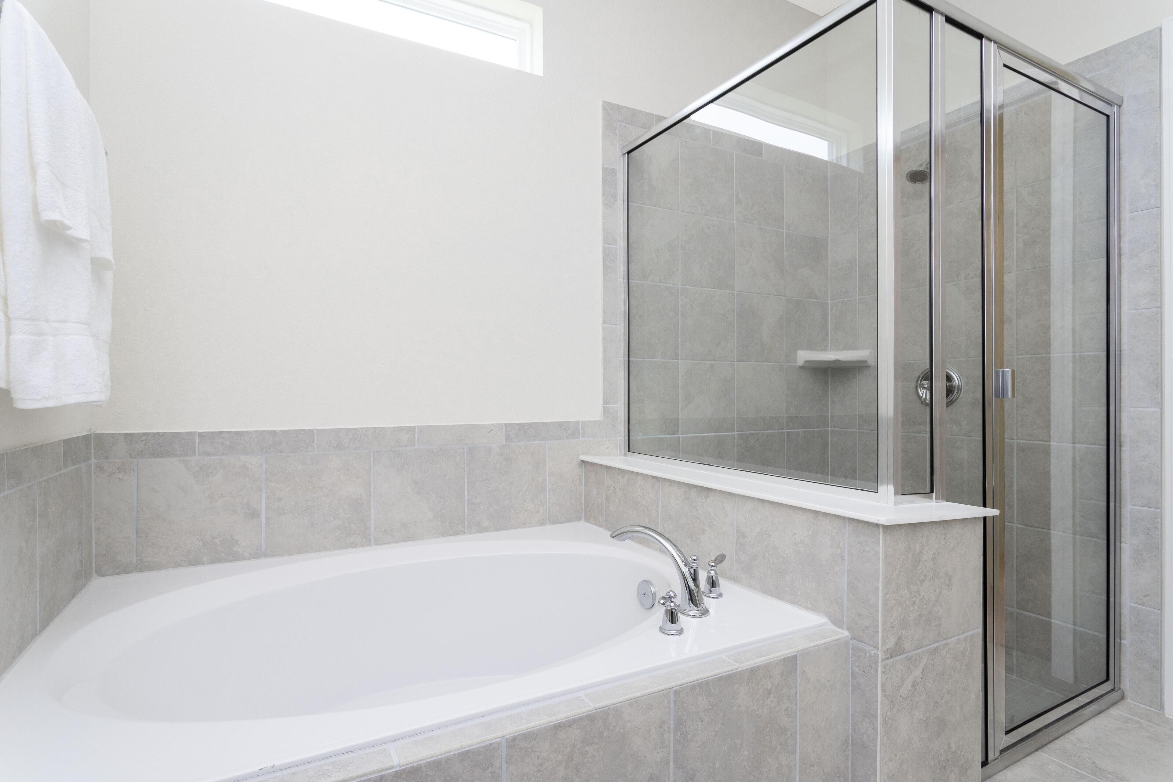 Ein modernes Badezimmer mit einer freistehenden Badewanne, einer Duschkabine und einem weißen Waschtisch.