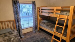 A room with a bunk bed, a window with curtains, a wooden ladder, and a carpeted floor. - Secluded camp off the snowmobile trail (New Sweden)