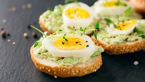 Un sandwich à l’avocat, à l’œuf et aux légumes verts, servi dans un pain à la farine de sésame.
