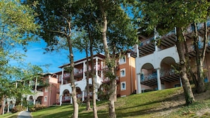 A hotel with multiple floors, outdoor balconies, and a pathway leading to the entrance.
