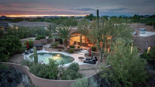 A residential property with a swimming pool, outdoor seating, and a landscaped garden. - Desert Hideaway+Shuffleboard Court+Golf+Billiards (Scottsdale)