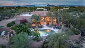 A modern house with a swimming pool, surrounded by desert vegetation and mountains in the background. - Desert Hideaway+Shuffleboard Court+Golf+Billiards (Scottsdale)