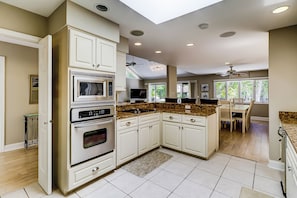 Enjoy cooking in this well-lit kitchen with a central island, microwave and oven, and granite countertop.