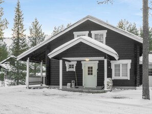 A wooden cabin with a gabled roof, a front porch, and a door with a window above it. - Rapsakka a by Interhome (Kittilä)