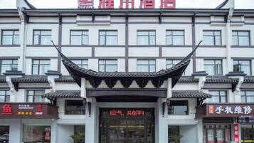 A hotel with a traditional Chinese architectural style, featuring a prominent curved roof and multiple windows.
