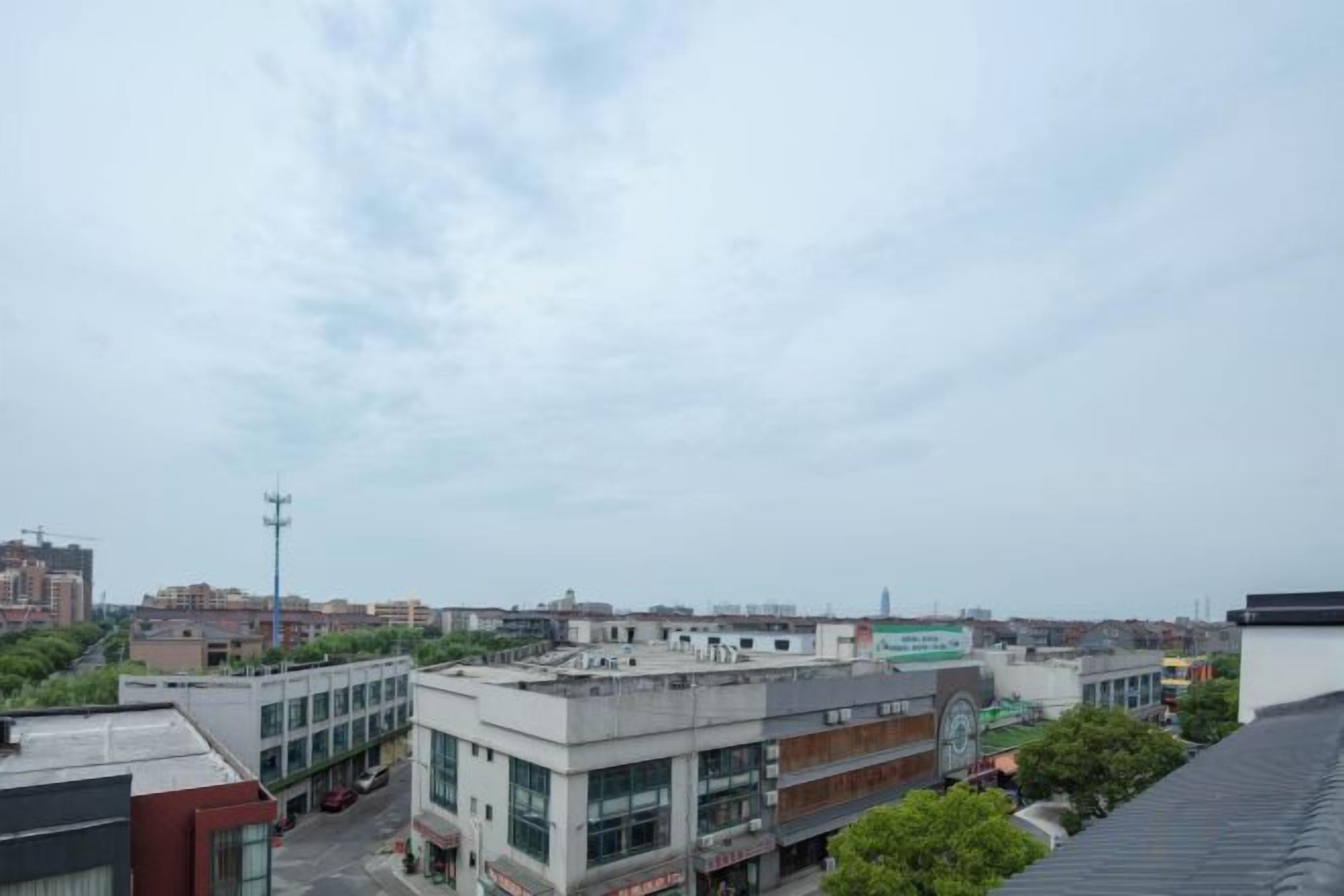 A cityscape with multiple buildings, including a prominent multi-story structure with large windows.