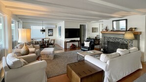 A spacious living room with a fireplace, a television, and comfortable seating.