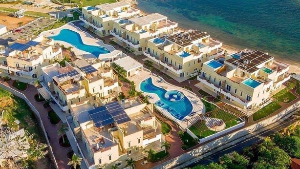 A resort with multiple buildings, swimming pools, and a beach. - Estudio in Las Palmas (Roatan)