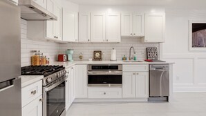 A modern kitchen with white cabinetry, stainless steel appliances, and a clock on the wall. - Georgetown - 1-BR- Apt #1-450 SF (Near CAMPUS)  (Washington)