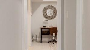 A hallway with a desk, chair, and a decorative wall piece. - Georgetown - 1-BR- Apt #1-450 SF (Near CAMPUS)  (Washington)