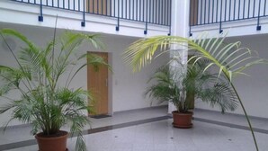 A spacious indoor area with a tiled floor and potted plants. - Modern vacation apartment right on the beach with balcony - Residenz am Strand (Zingst)