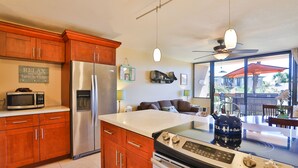 Una cocina moderna con armarios de madera, electrodomésticos de acero inoxidable y una isla grande con un hervidor.