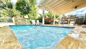 A swimming pool with a tiled edge, surrounded by lounge chairs and a covered seating area. - Serenity By the Beach, Private pool & El Yunque rainforest. 2BR. - 2 FULL BA. (Luquillo)