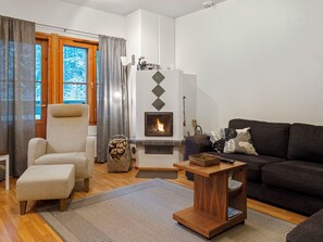 A cozy living room with a fireplace, a sofa, a chair, and a coffee table.