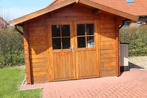 Una cabaña de madera con un camino de ladrillo que lleva a la entrada.