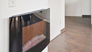 A modern kitchen with a built-in oven, a white wall, and a wooden floor.