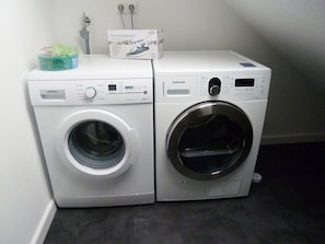 Two stacked washing machines in a laundry room.