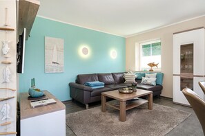 Uma sala de estar moderna com um sofá, mesa de centro e objetos decorativos.