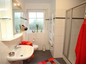 A bathroom with a sink, toilet, and shower.
