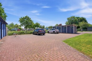 A paved driveway leading to a building with a car parked in front.