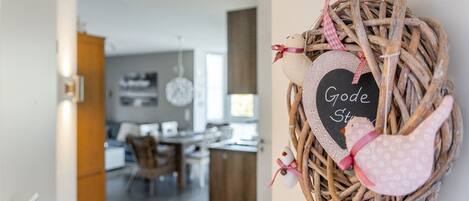 A wicker basket with a heart-shaped sign reading "Good Stuff" hanging on a wall.
