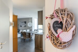 A wicker basket with a heart-shaped sign reading "Good Stuff" hanging on a wall. - Gode Stuuv - Our "good room" (75sqm) for 4 persons centrally located in Greetsiel (Krummhörn)