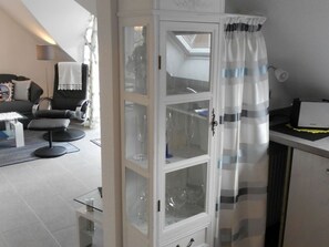 Un salon moderne avec une vitrine contenant des verres à vin, un canapé et une table basse.
